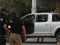 Policías resguardan una camioneta donde viajaba un hombre que fue atacado por sujetos armados, en la jornada violenta registrada ayer en Ciudad Juárez, Chihuahua. EFE / L. Torres
