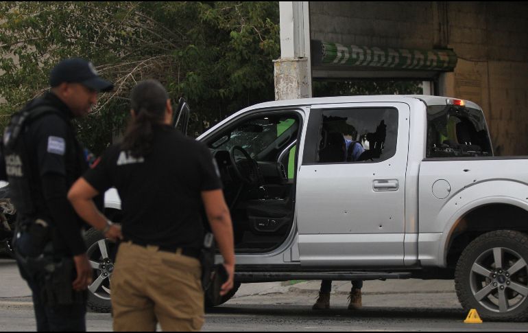 Policías resguardan una camioneta donde viajaba un hombre que fue atacado por sujetos armados, en la jornada violenta registrada ayer en Ciudad Juárez, Chihuahua. EFE / L. Torres